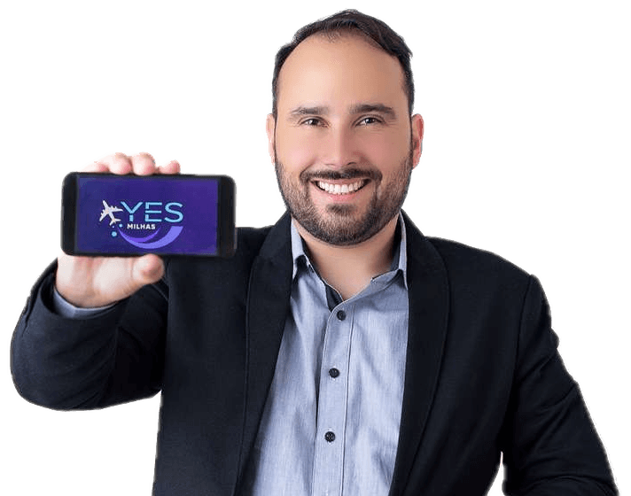 Zé Roberto segurando um celular com o logo da Yes Milhas